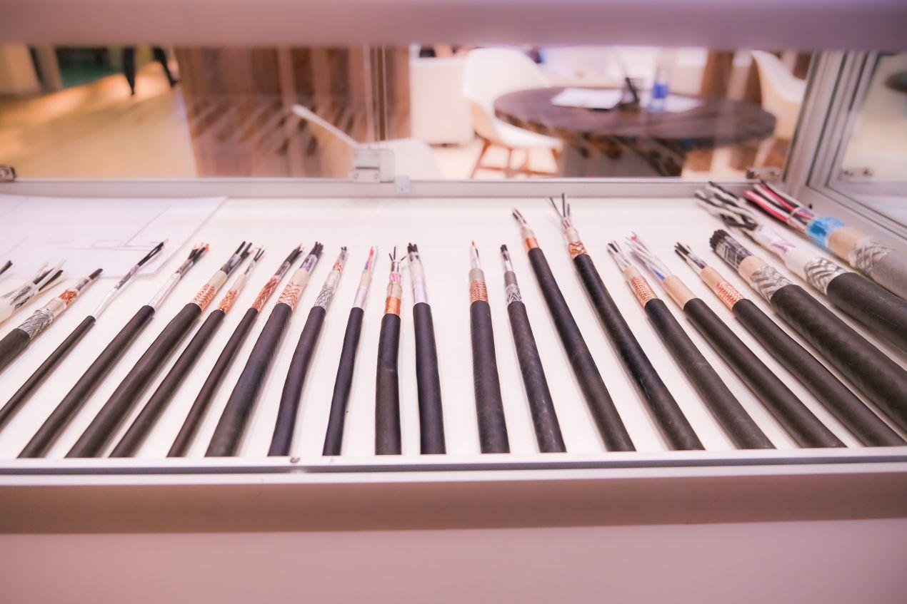 Vitrine mit verschiedenen Kupferkabeltypen – Vergleich zu platzsparender MTP-Glasfaserverkabelung in modernen Netzwerken