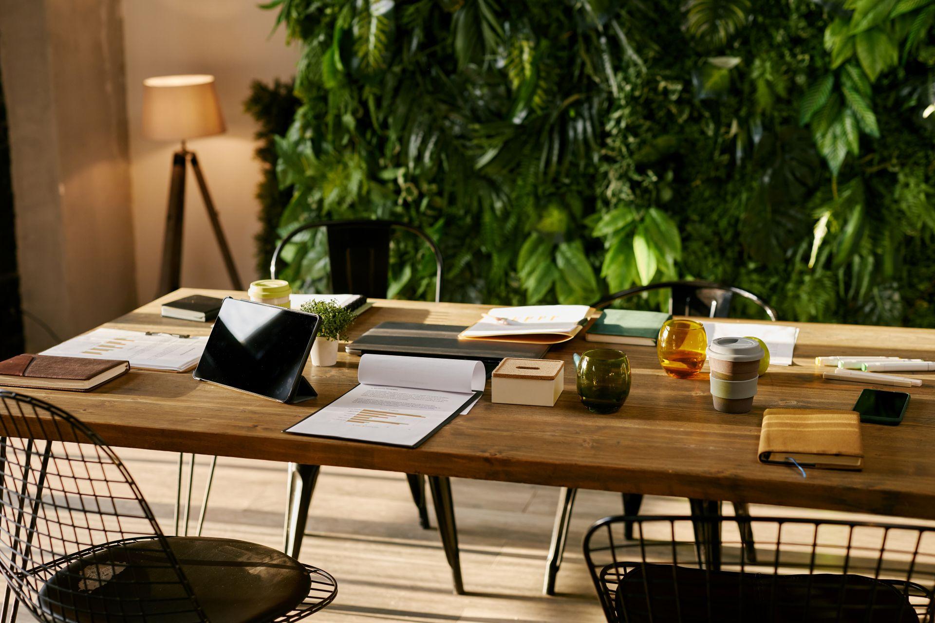Kuenstliche Pflanzenwand als Design-Element in kleinem Co-Working Space mit Holzmoebeln
